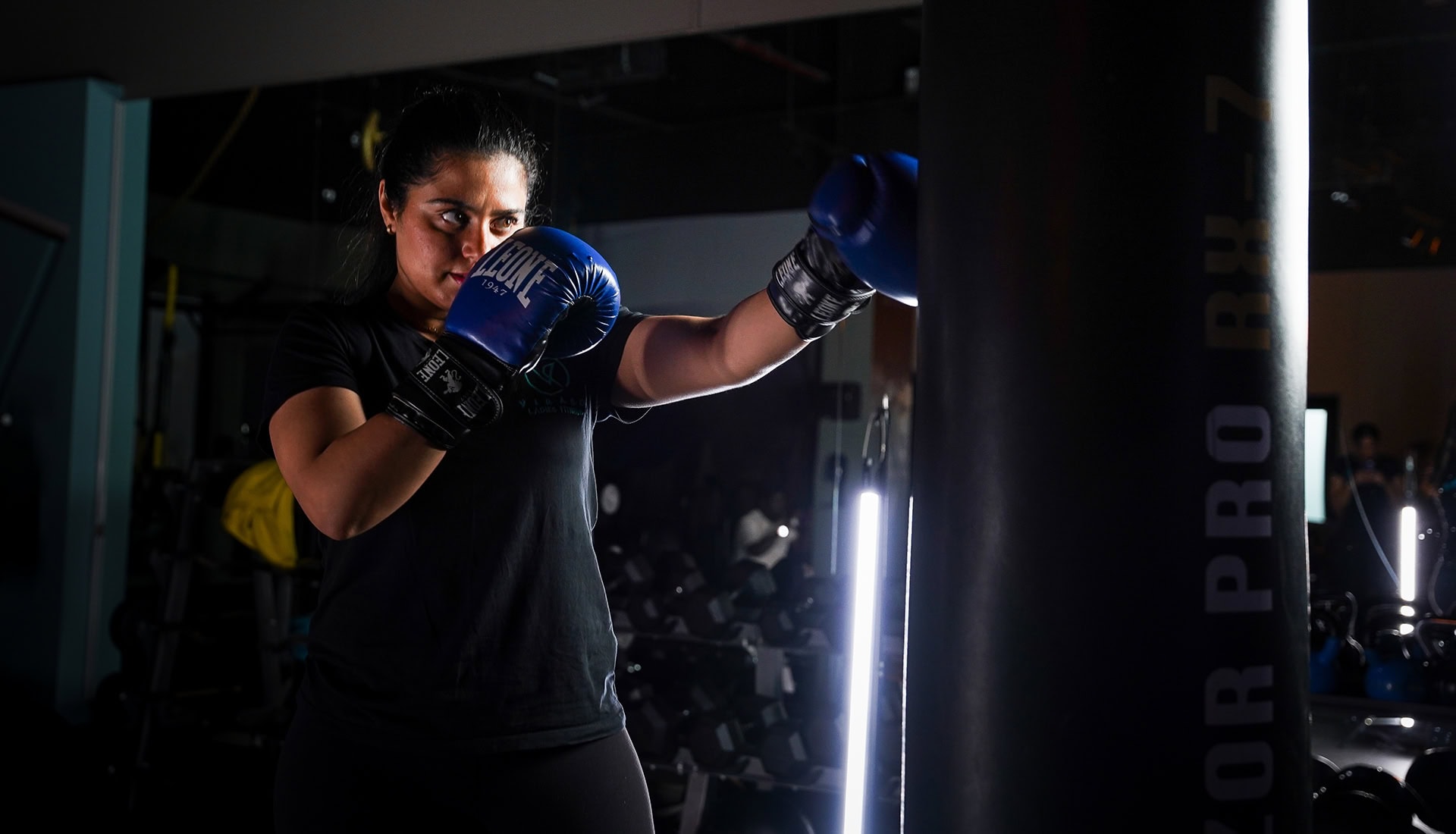 boxing-rev-img-1 Female boxer training with gloves under neon lights