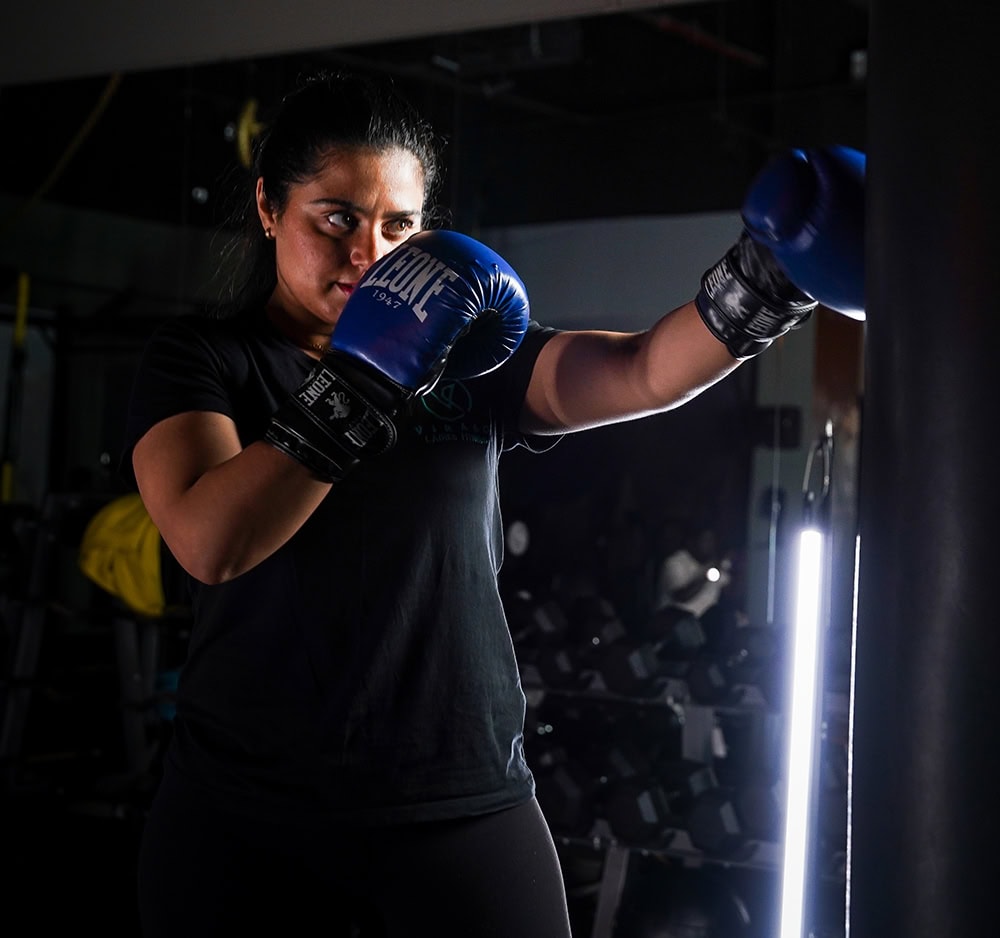 Woman boxing in gloves with intense expression