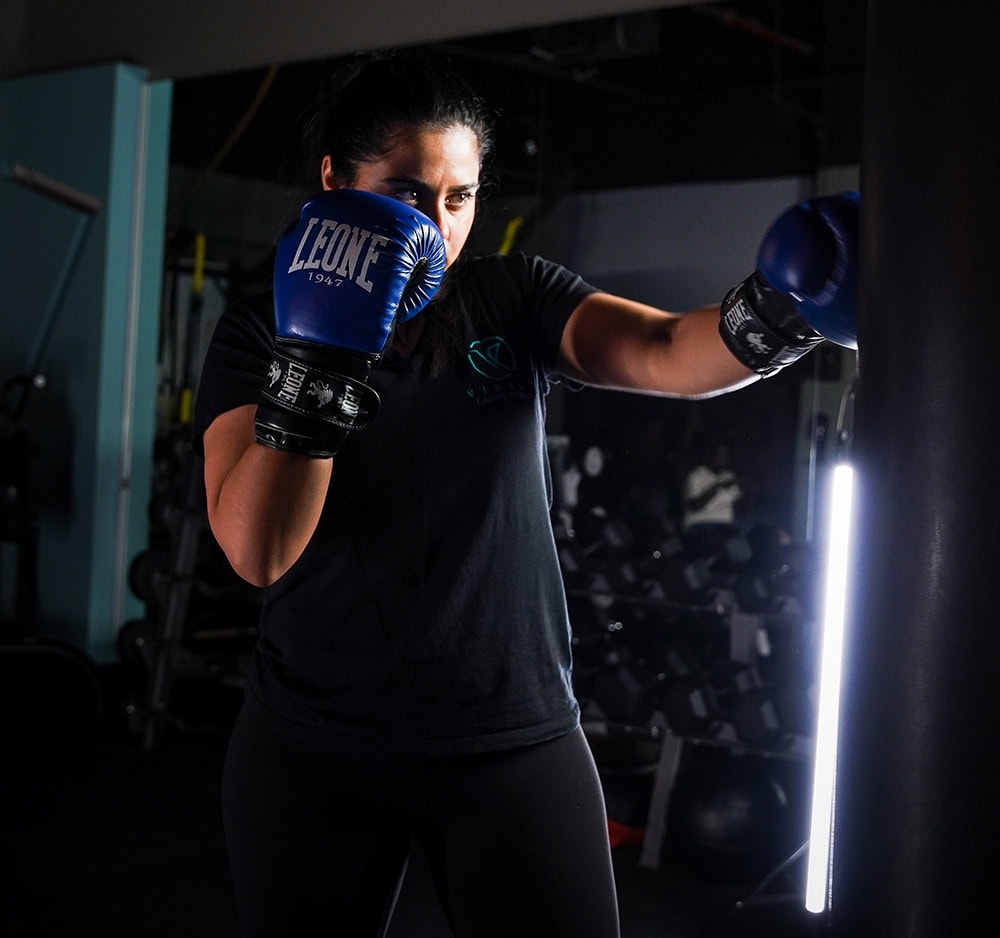 Female boxer mid-punch in professional gym