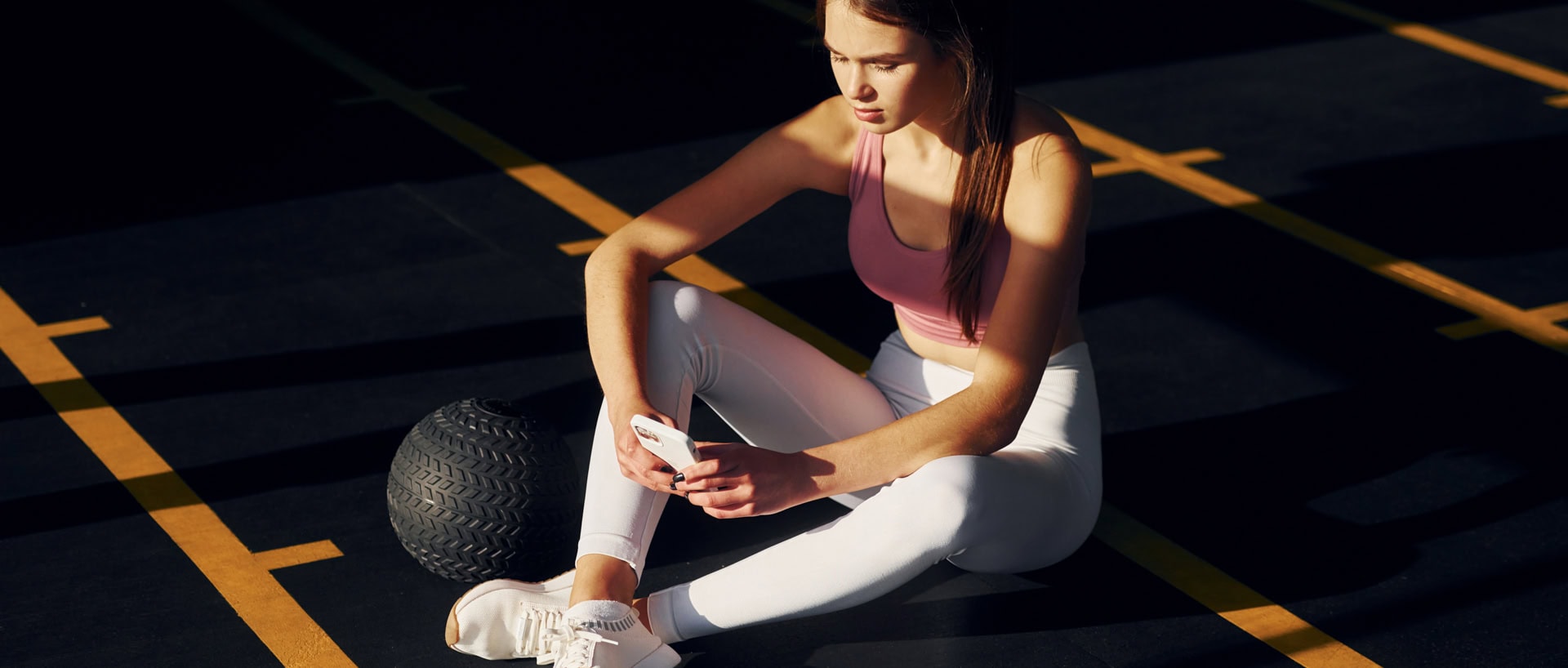 Woman in activewear stretching on gym mat post-workout