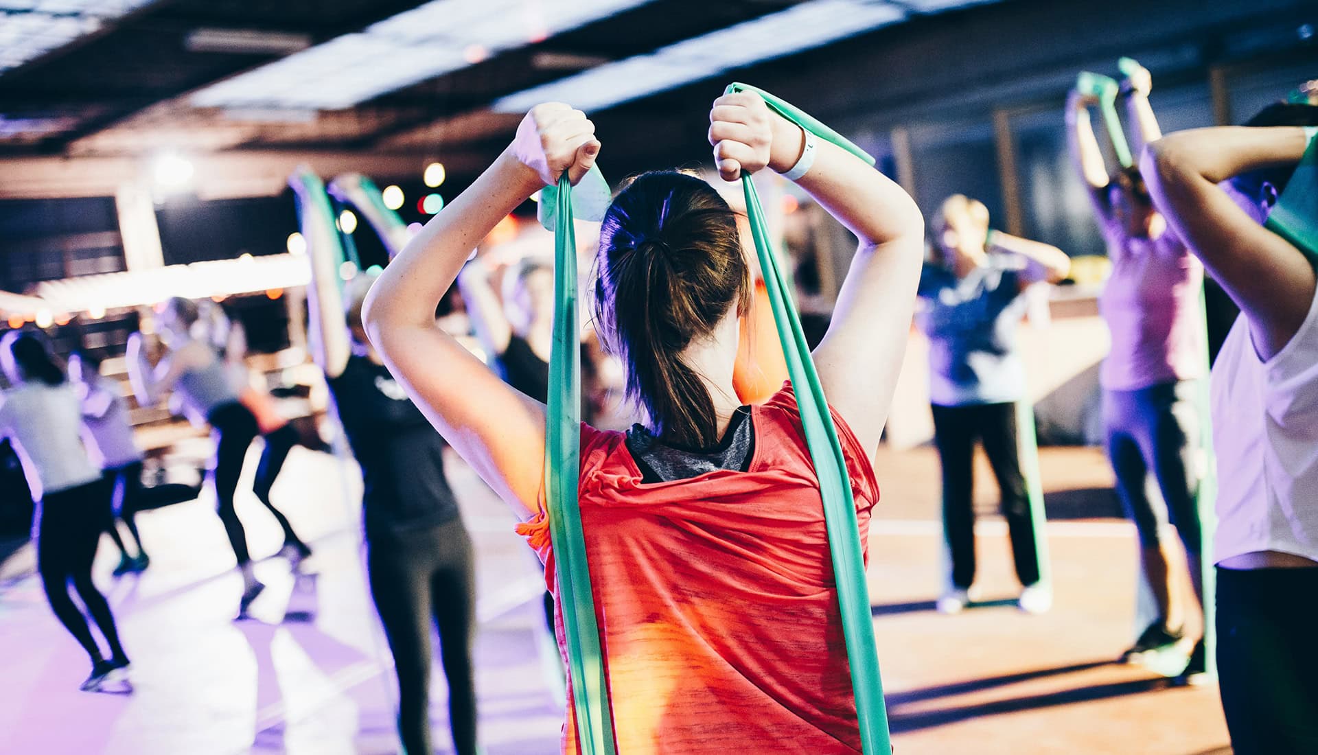 Group of women doing overhead stretches in fitness class