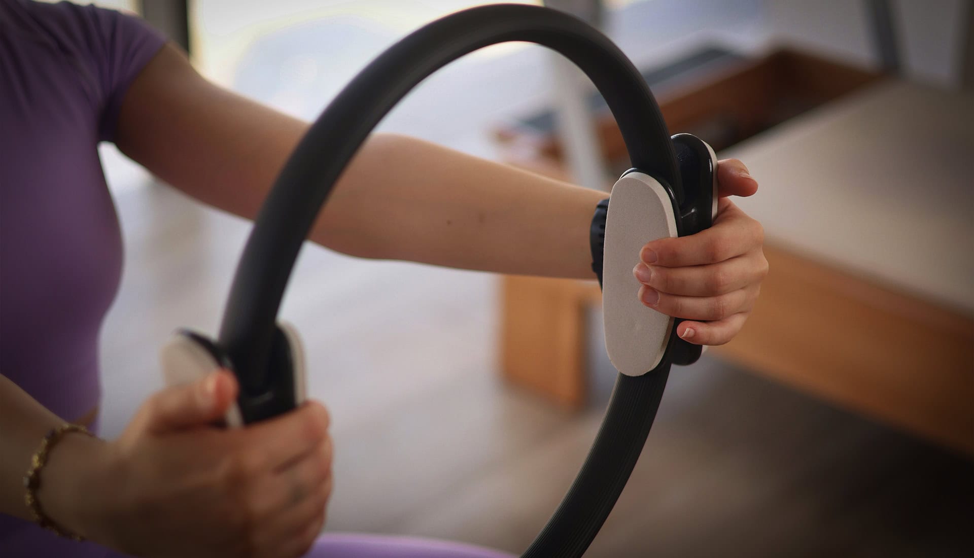 Hands holding Pilates ring during mat pilates session