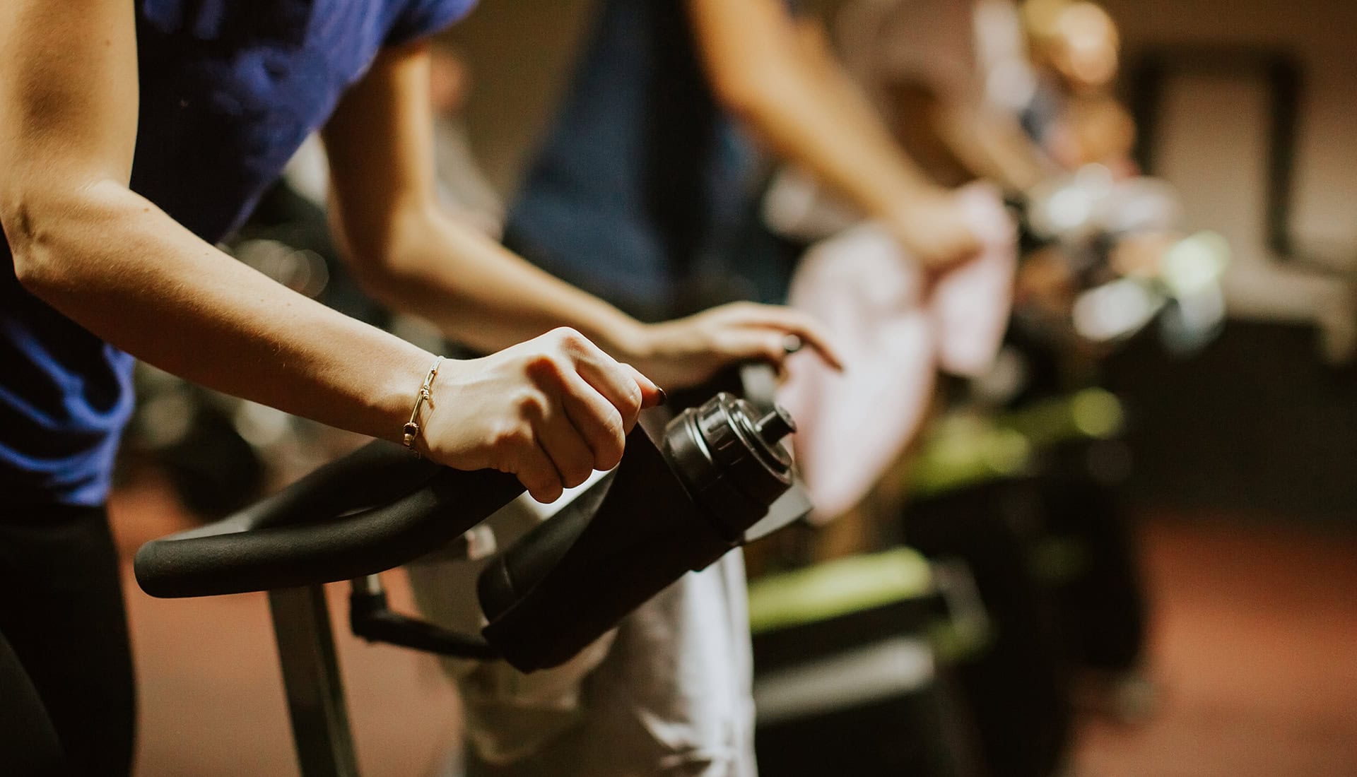 Close-up of hands adjusting gym bike pedals