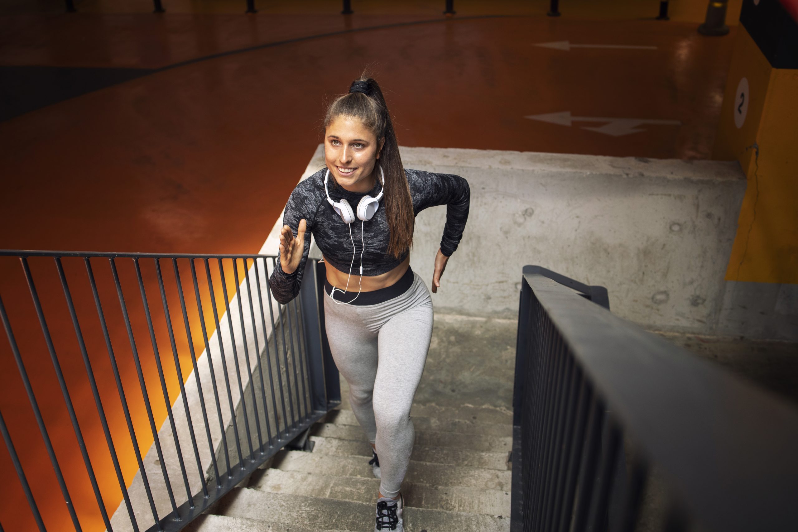 Busy woman doing a HIIT workout with kettlebell swings in a modern gym