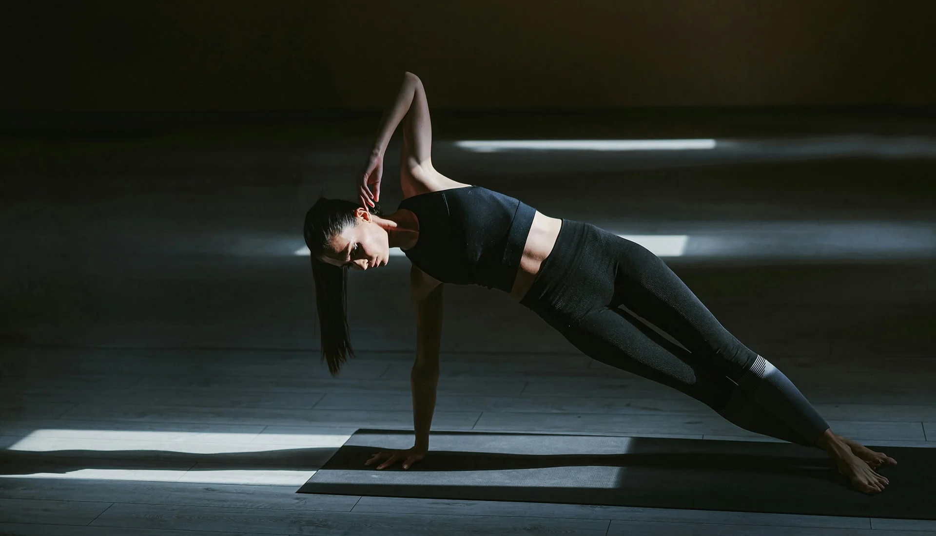 Woman performing reverse plank exercise on yoga mat