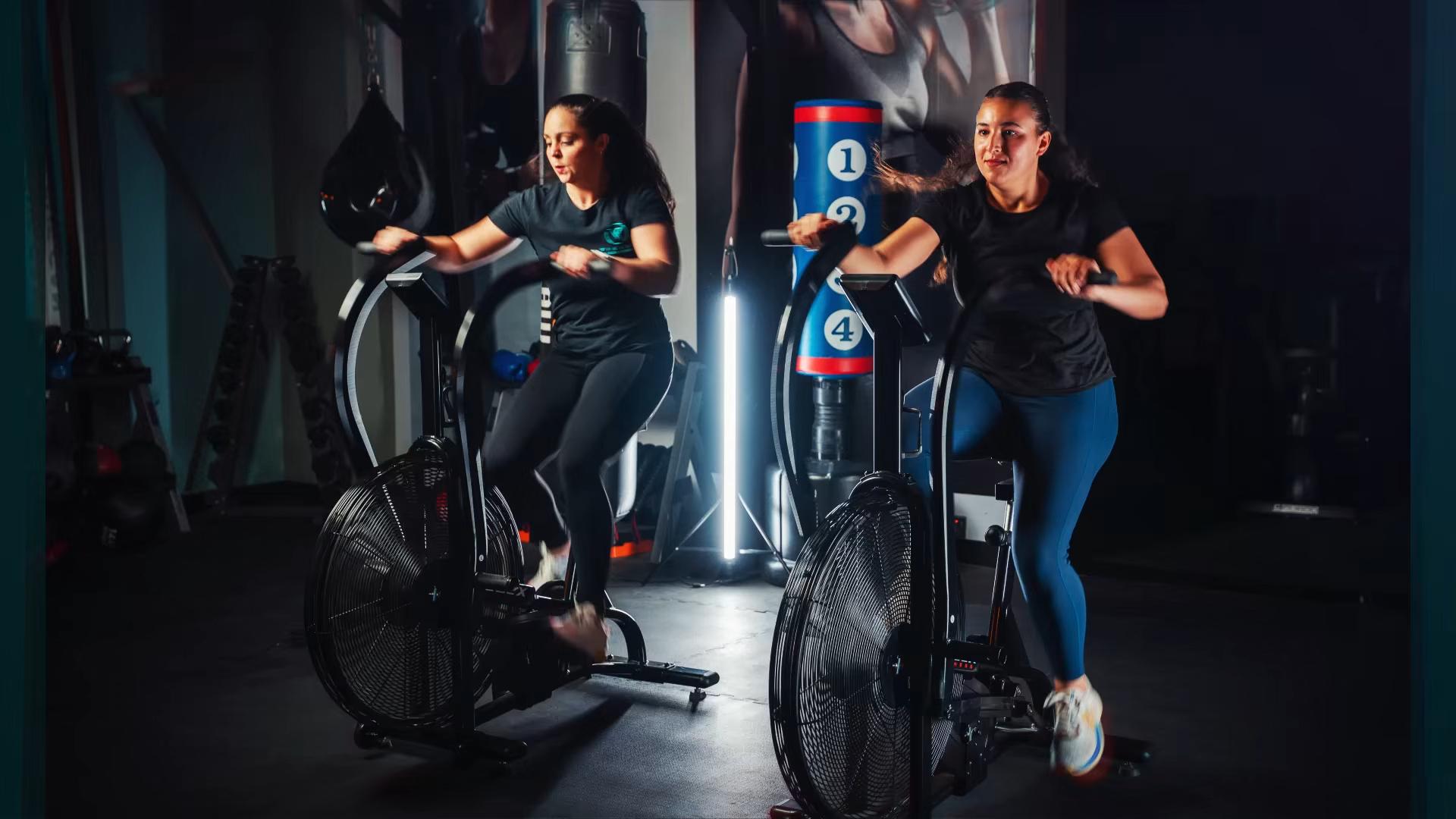 Intense spin class workout session with two women pedaling